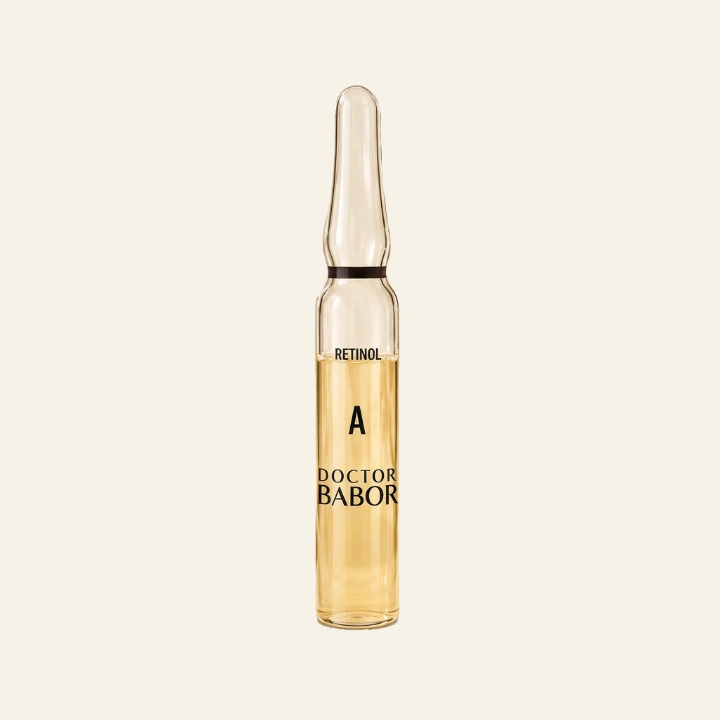 DOCTOR BABOR Retinol Ampulle auf elegantem beigem Spa-Hintergrund – luxuriöse Wirkstoffampulle mit Retinol zur Unterstützung der Hauterneuerung, eines glatteren Hautbildes und sichtbar verfeinerter Hautstruktur.