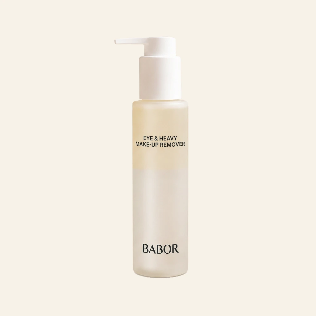 BABOR Eye & Heavy Make-Up Remover in eleganter Pumpflasche vor modernem Spa-Hintergrund mit warmen Beige- und Cremetönen, Naturstein und stilvollen Wellness-Elementen. Hochwertige Beauty-Produktinszenierung mit cleanem Luxus-Look und entspannender Spa-Atmosphäre
