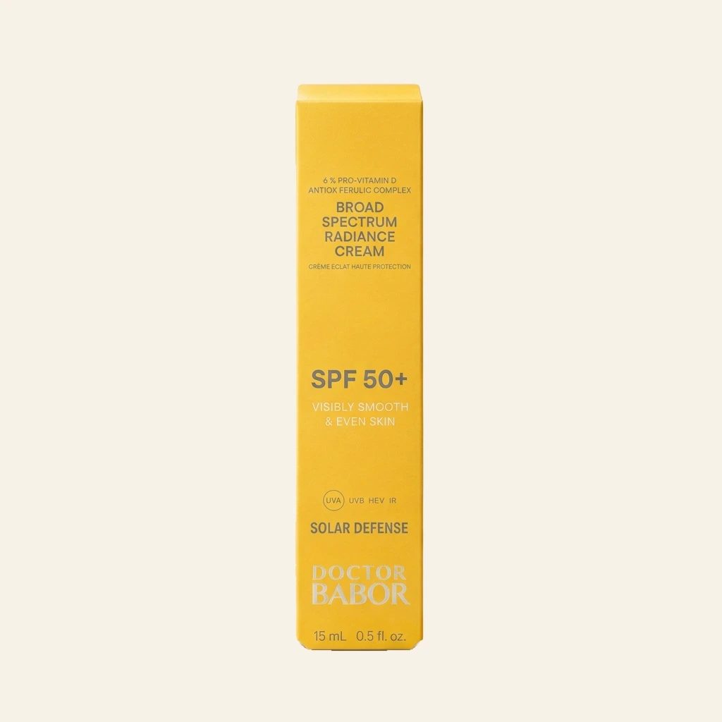 DOCTOR BABOR Solar Defense Broad Spectrum Radiance Cream SPF 50+ auf elegantem beigem Spa-Hintergrund – luxuriöse Anti-Aging Sonnenpflege mit UVA-, UVB-, HEV- und IR-Schutz für glatte und ebenmäßige Haut.