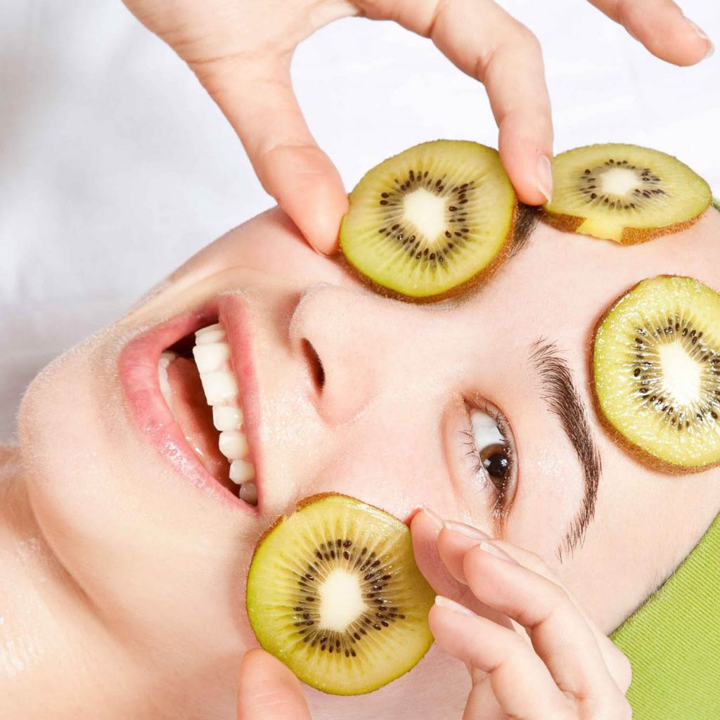 Woman with kiwi slices on her face