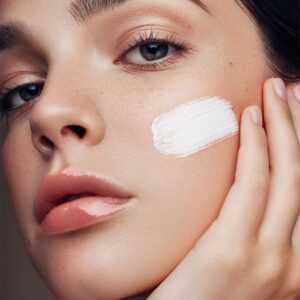 Reversiv | HopeCosmetics Junge Frau mit Creme im Gesicht